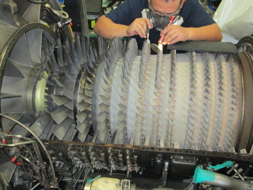 Man repairing airplane engine 